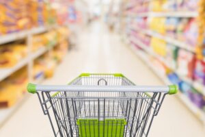 shopping-cart-with-abstract-blur-supermarket-discount-store-aisle-pet-food-product-shelves-scaled-1